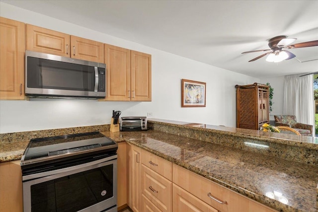 kitchen with a ceiling fan, light brown cabinets, dark stone counters, and appliances with stainless steel finishes