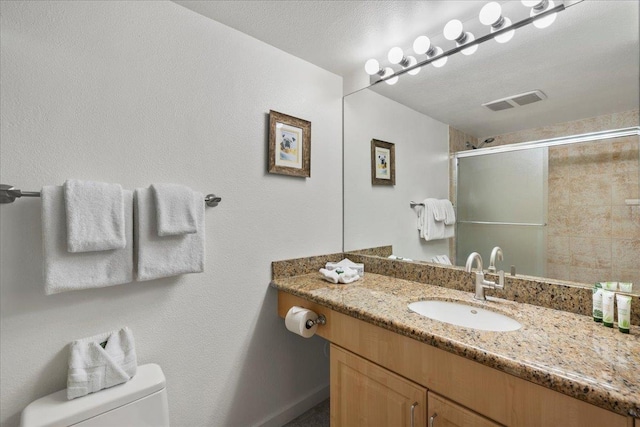 bathroom featuring baseboards, toilet, visible vents, a shower stall, and vanity