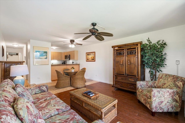 living room featuring wood finished floors, baseboards, and ceiling fan