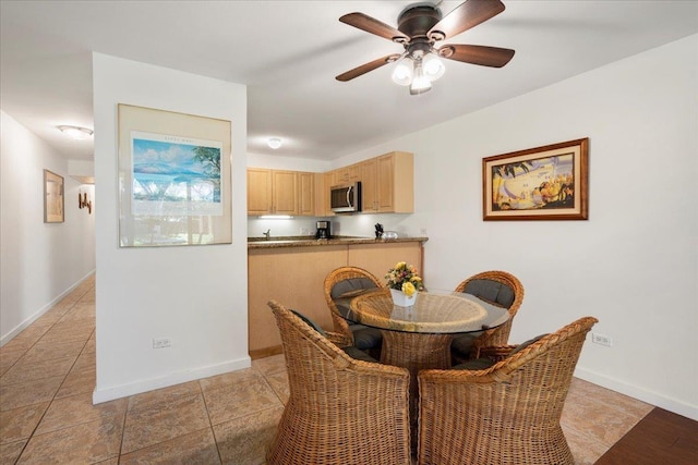 dining space with baseboards and a ceiling fan