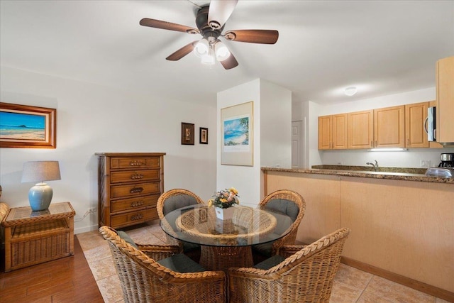 dining space with baseboards and ceiling fan
