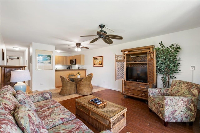 living room with baseboards, wood finished floors, and a ceiling fan