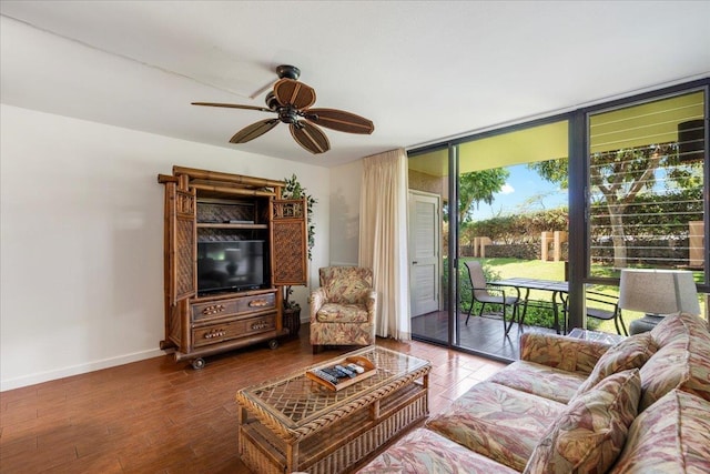 living area featuring expansive windows, baseboards, a ceiling fan, and wood finished floors