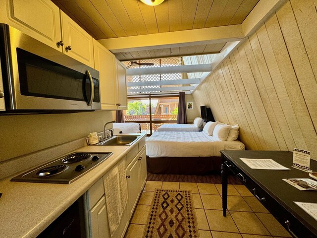 tiled bedroom featuring sink, wood ceiling, wood walls, and beamed ceiling