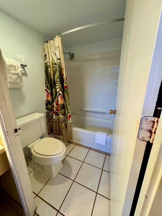 bathroom featuring toilet, shower / tub combo, and tile patterned floors