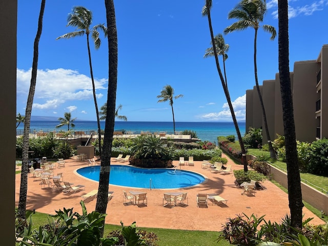 view of swimming pool with a patio and a water view