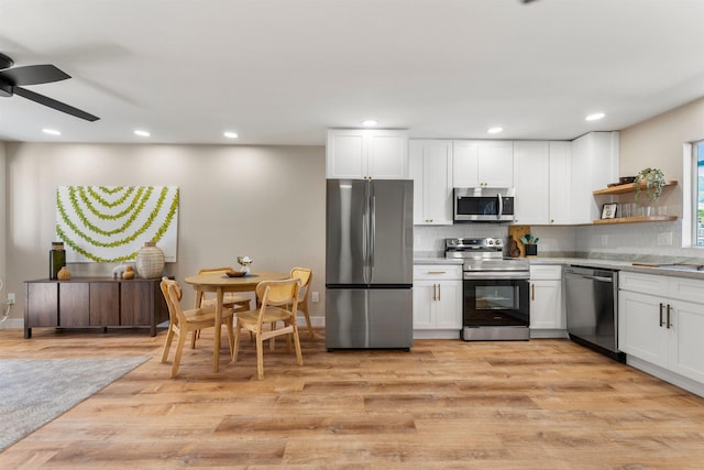 kitchen with tasteful backsplash, stainless steel appliances, ceiling fan, light hardwood / wood-style flooring, and white cabinets