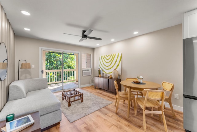 living room featuring ceiling fan, cooling unit, and light hardwood / wood-style floors