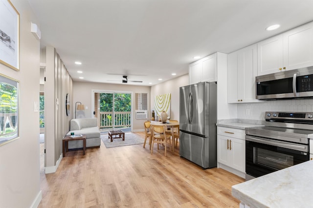 kitchen featuring backsplash, light hardwood / wood-style flooring, white cabinets, and appliances with stainless steel finishes