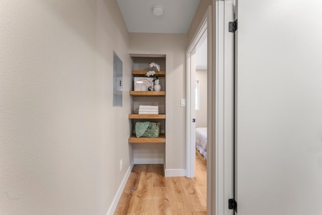 hallway with light hardwood / wood-style floors and electric panel