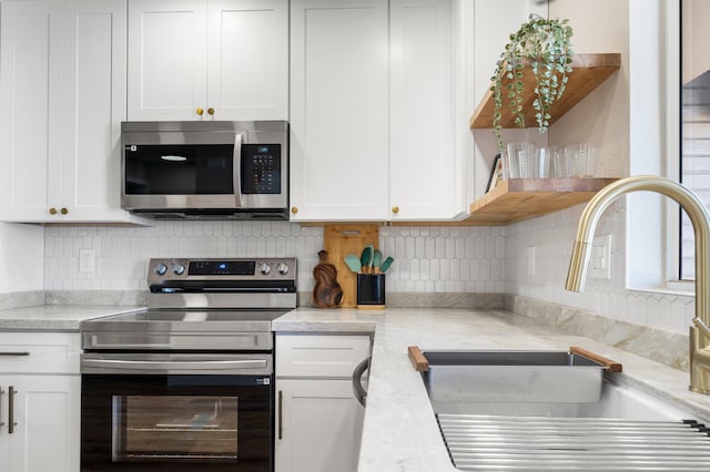 kitchen featuring white cabinets, stainless steel appliances, and sink