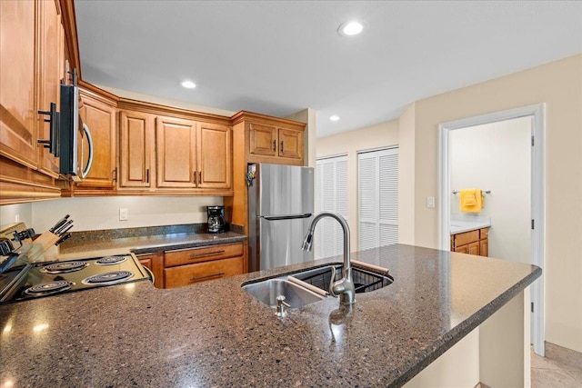 2777 S Kihei Rd Unit L-109, Kihei, HI 96753 - kitchen featuring appliances with stainless steel finishes, dark stone counters, brown cabinetry, recessed lighting, and a peninsula