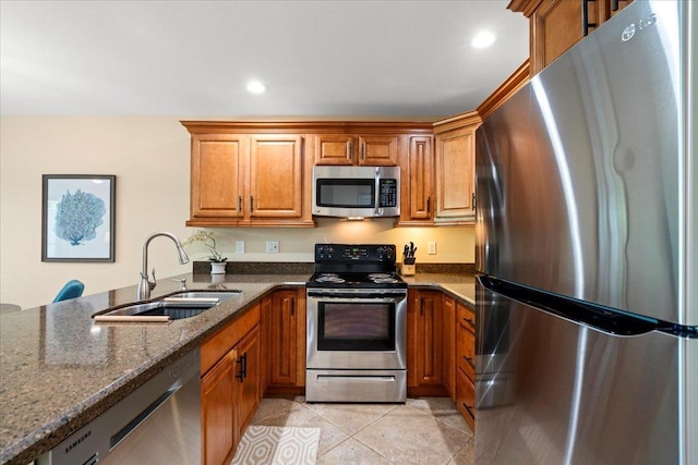2777 S Kihei Rd Unit L-109, Kihei, HI 96753 - kitchen with stainless steel appliances, brown cabinets, dark stone counters, light tile patterned floors, and a peninsula