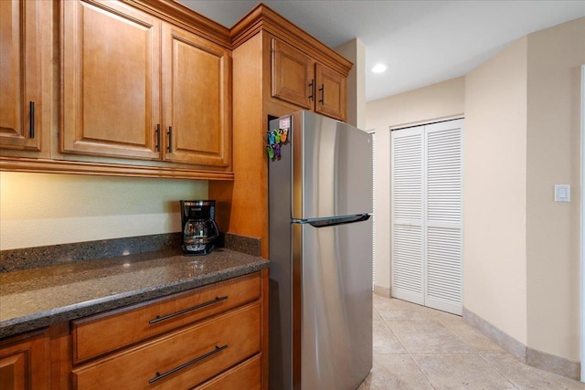 2777 S Kihei Rd Unit L-109, Kihei, HI 96753 - kitchen featuring freestanding refrigerator, brown cabinets, dark stone counters, light tile patterned floors, and recessed lighting