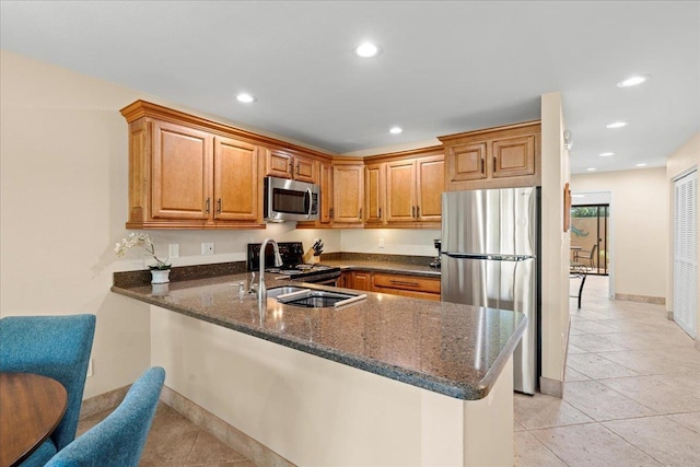 2777 S Kihei Rd Unit L-109, Kihei, HI 96753 - kitchen featuring appliances with stainless steel finishes, dark stone counters, a peninsula, recessed lighting, and brown cabinets
