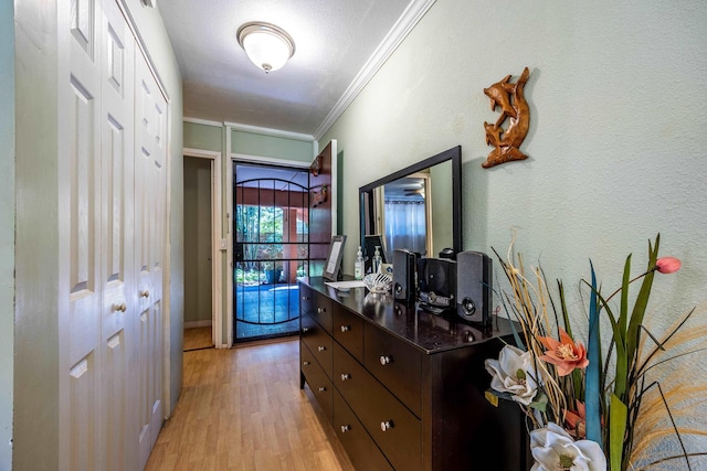 corridor featuring ornamental molding and light wood-type flooring