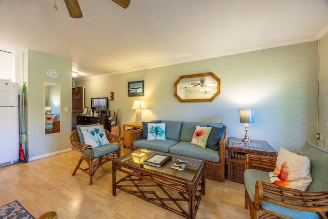 living room with light hardwood / wood-style floors, ornamental molding, and ceiling fan