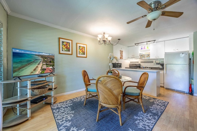 dining space with crown molding, ceiling fan with notable chandelier, and light hardwood / wood-style flooring