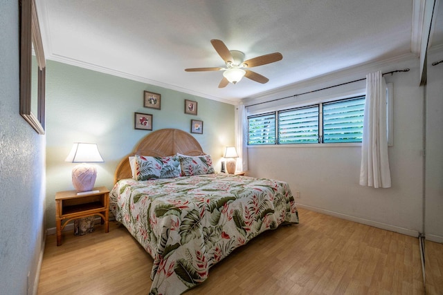 bedroom featuring ceiling fan, light hardwood / wood-style flooring, and crown molding