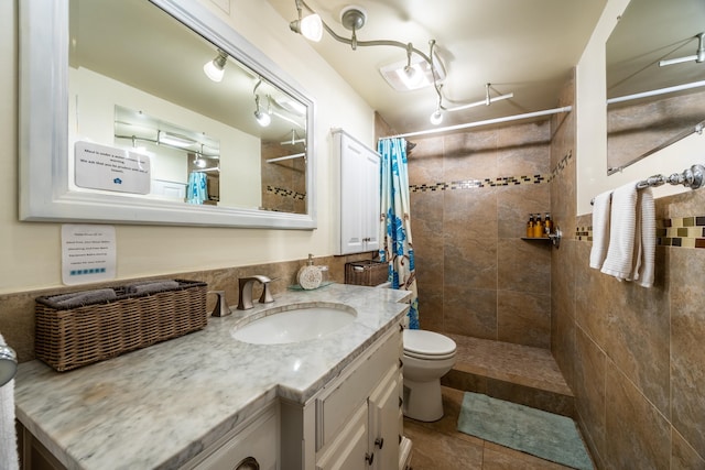 bathroom with curtained shower, toilet, tile patterned flooring, and vanity