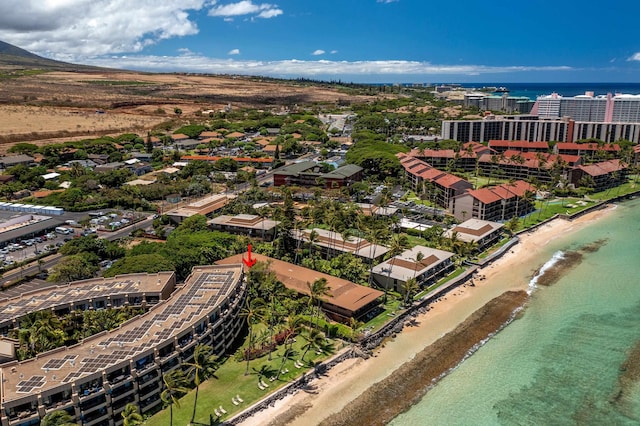 birds eye view of property with a water view and a beach view