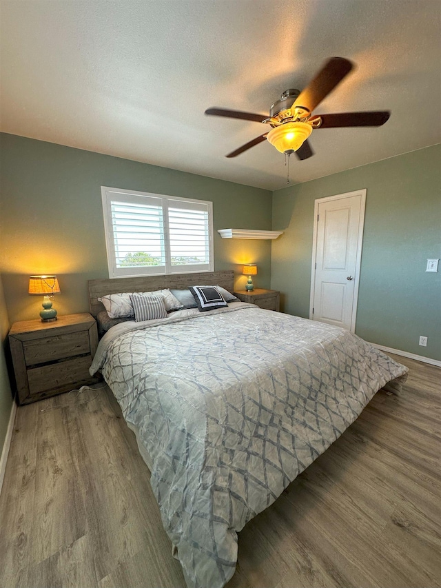 bedroom featuring hardwood / wood-style floors, a textured ceiling, and ceiling fan