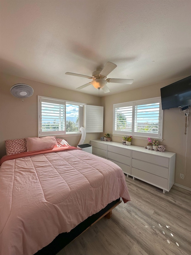 bedroom with ceiling fan and light wood-type flooring