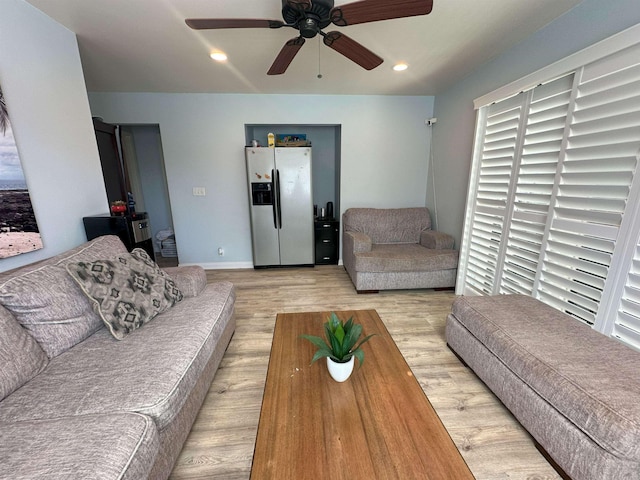 living room featuring ceiling fan and light hardwood / wood-style floors