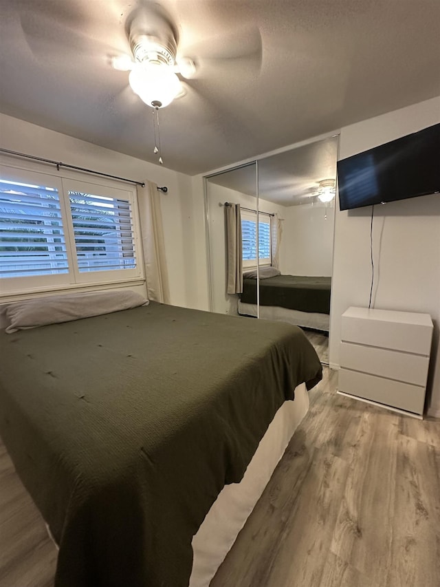 bedroom with a closet, ceiling fan, and hardwood / wood-style flooring