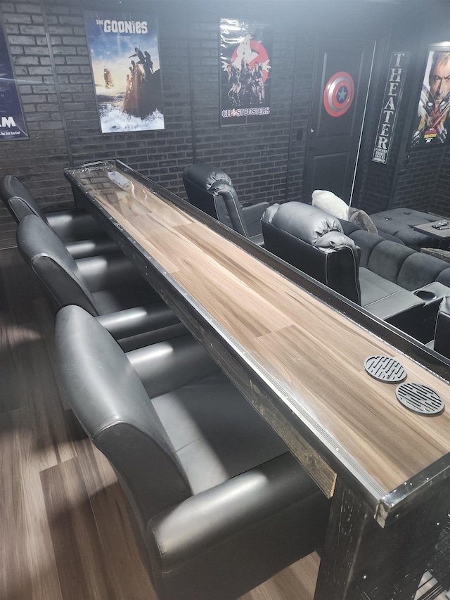 bar featuring hardwood / wood-style floors and brick wall