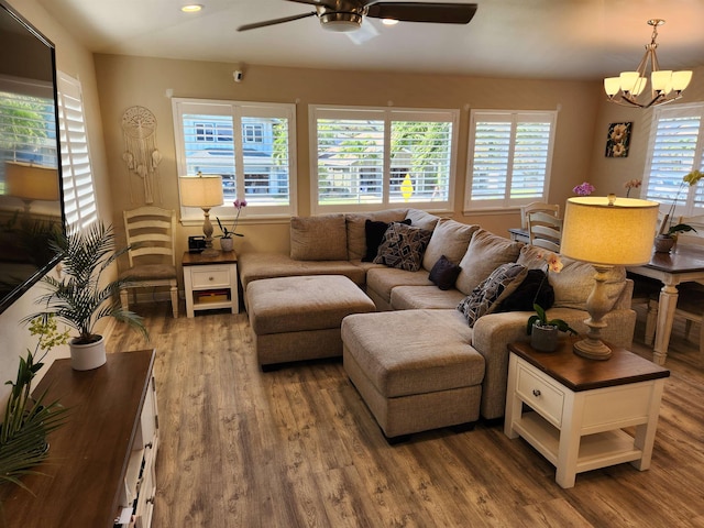 living room featuring hardwood / wood-style floors and ceiling fan with notable chandelier