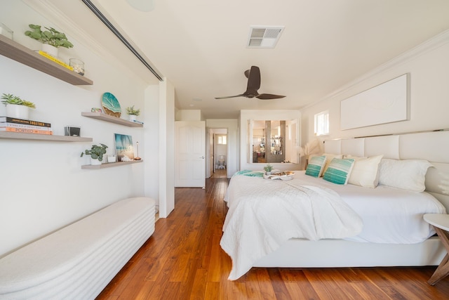 bedroom with crown molding, ceiling fan, and dark hardwood / wood-style flooring