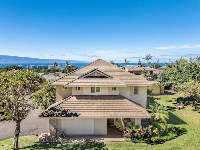 view of front of house with a mountain view, a patio area, and a front lawn