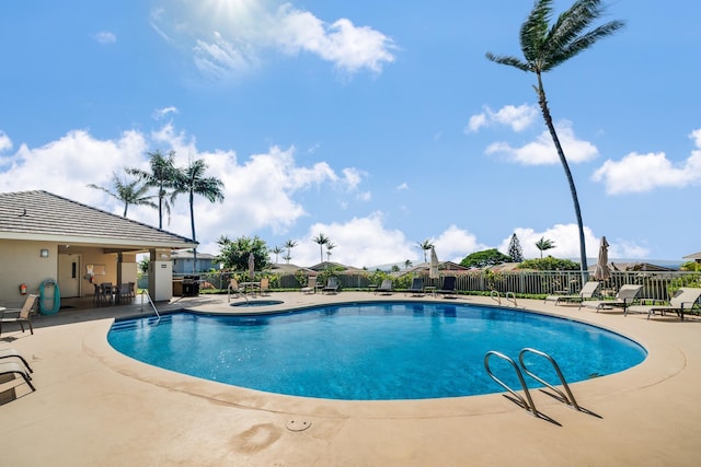 view of swimming pool featuring a patio and a hot tub