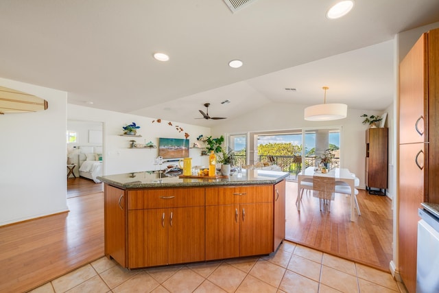 kitchen featuring lofted ceiling, decorative light fixtures, kitchen peninsula, light tile patterned flooring, and ceiling fan