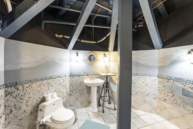 bathroom with tile patterned flooring, toilet, and tile walls