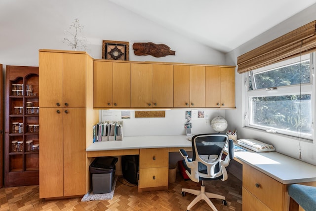 home office featuring built in desk, light parquet floors, and lofted ceiling