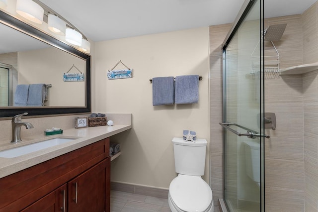 bathroom featuring vanity, a shower with shower door, and toilet