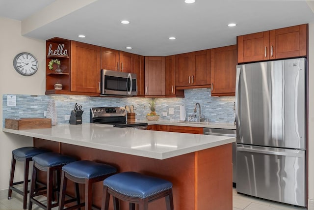 kitchen featuring sink, a kitchen breakfast bar, kitchen peninsula, and appliances with stainless steel finishes