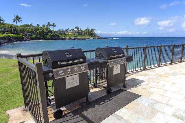 view of patio with area for grilling and a water view