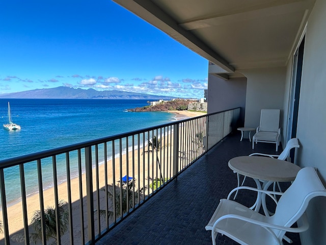 balcony featuring a water and mountain view and a view of the beach