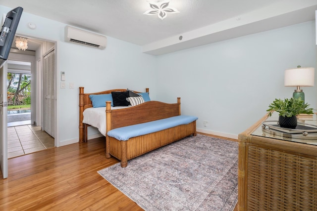 3788 Lower Honoapiilani Rd Unit C102, Lahaina, HI 96761 - bedroom with a wall mounted air conditioner, light wood-style floors, and baseboards