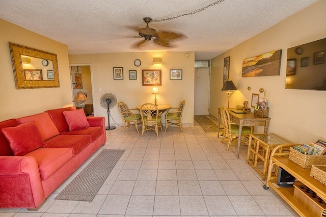 tiled living room featuring ceiling fan and a textured ceiling