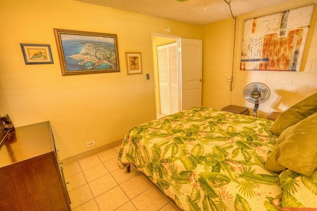 bedroom with a textured ceiling and light tile patterned floors