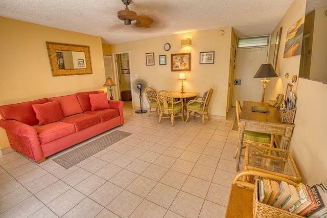 tiled living room featuring ceiling fan and a textured ceiling