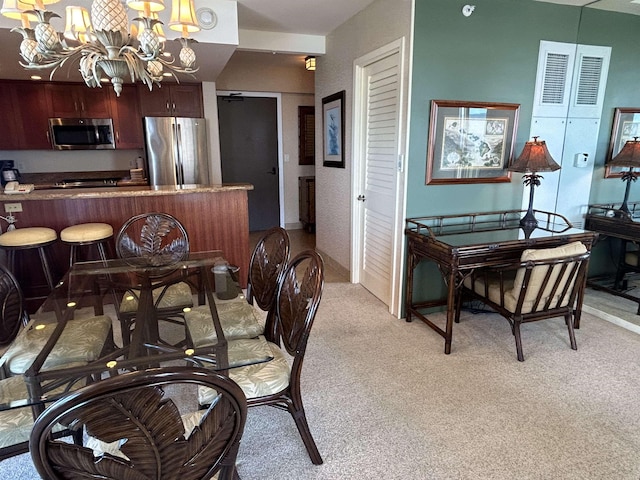 dining space featuring a notable chandelier and light colored carpet