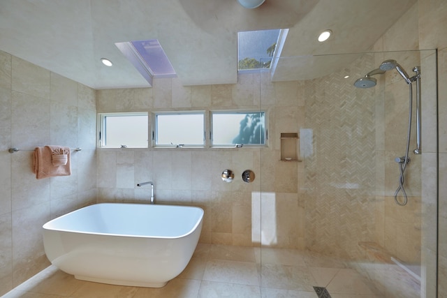 bathroom with plus walk in shower, tile walls, and a healthy amount of sunlight