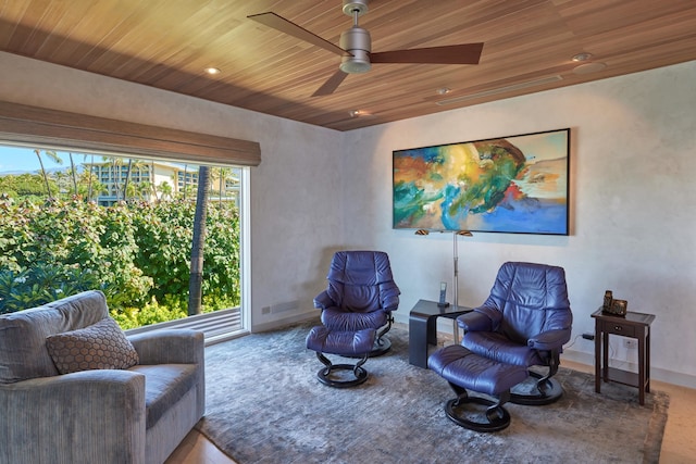 living area with wood ceiling and ceiling fan