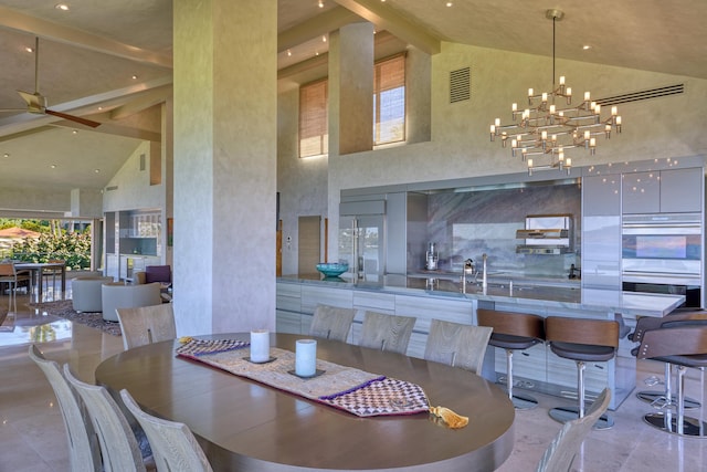 dining room featuring ceiling fan with notable chandelier, beam ceiling, and high vaulted ceiling