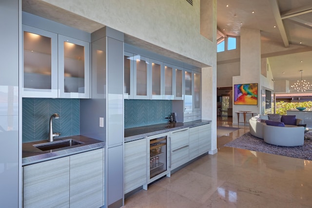 kitchen with beamed ceiling, sink, beverage cooler, high vaulted ceiling, and dark stone counters